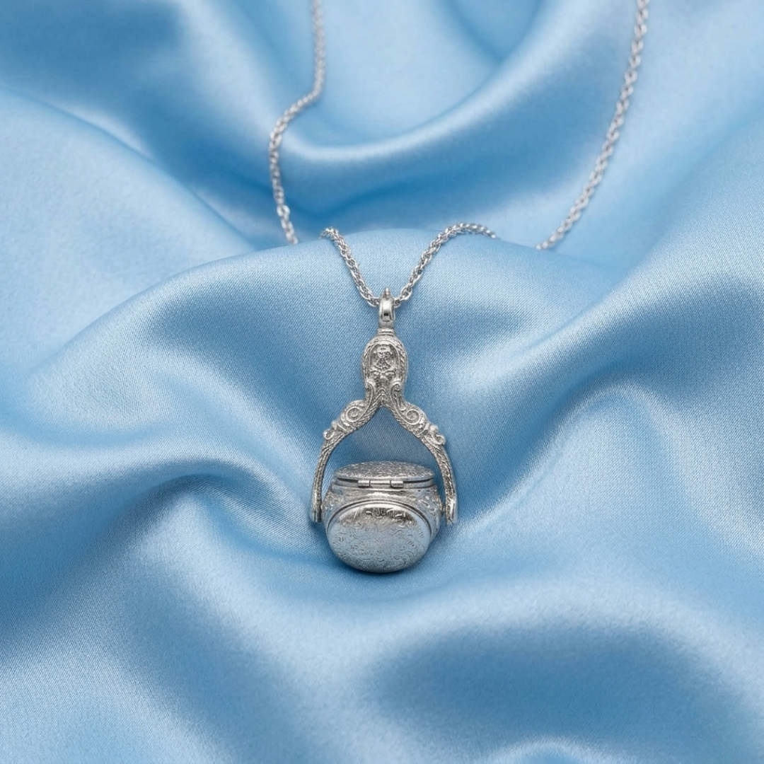 Silver necklace with a spinner pendant on a light blue satin background