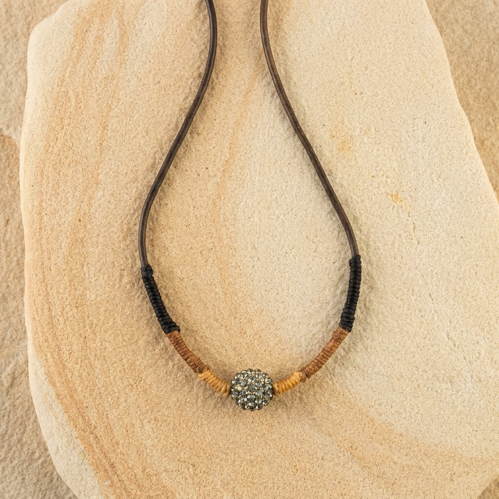 Black Diamond Fireball Crystal Brown Leather Cord Linen Wrapped Necklace on a stone surface