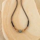Black Diamond Fireball Crystal Brown Leather Cord Linen Wrapped Necklace on a stone surface