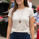 Woman wearing a necklace with an American Flag dog tag pendant in an outdoor barbecue setting
