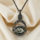 Decorative necklace with a spinner gemstone pendant on a beige fabric background