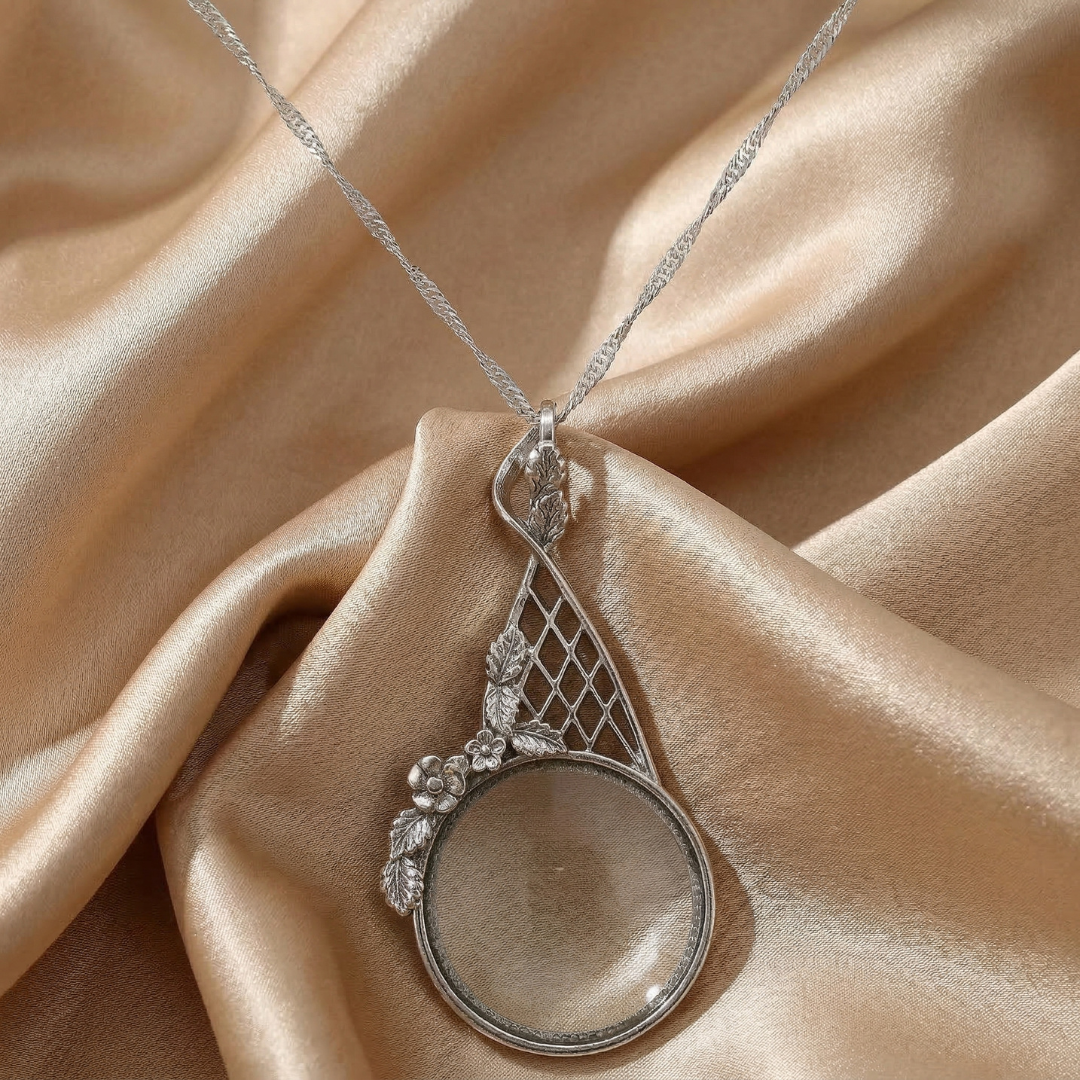 Silver necklace with a magnifying glass pendant on a beige fabric background
