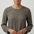 Person wearing a long-sleeve brown top with a Antiqued Pewter Lock Pendant Necklace
