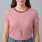 Person wearing a red and white striped shirt with a blue pave crystal whistle pendant necklace