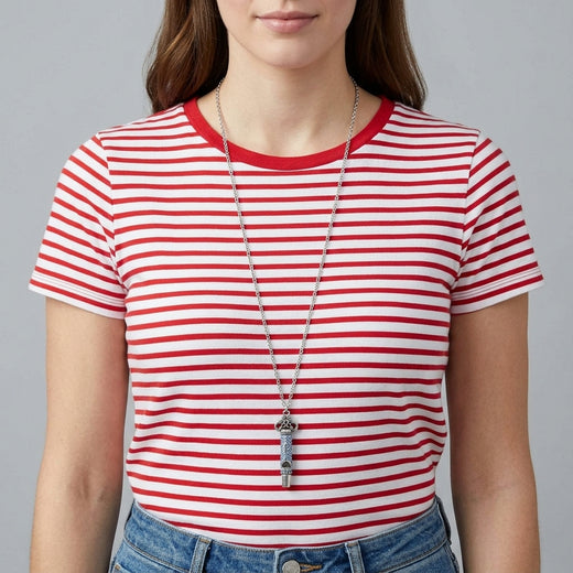 Person wearing a red and white striped shirt with a blue pave crystal whistle pendant necklace
