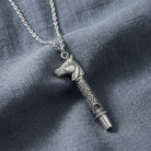 Silver tone Horse Head Whistle Necklace  against a gray fabric background