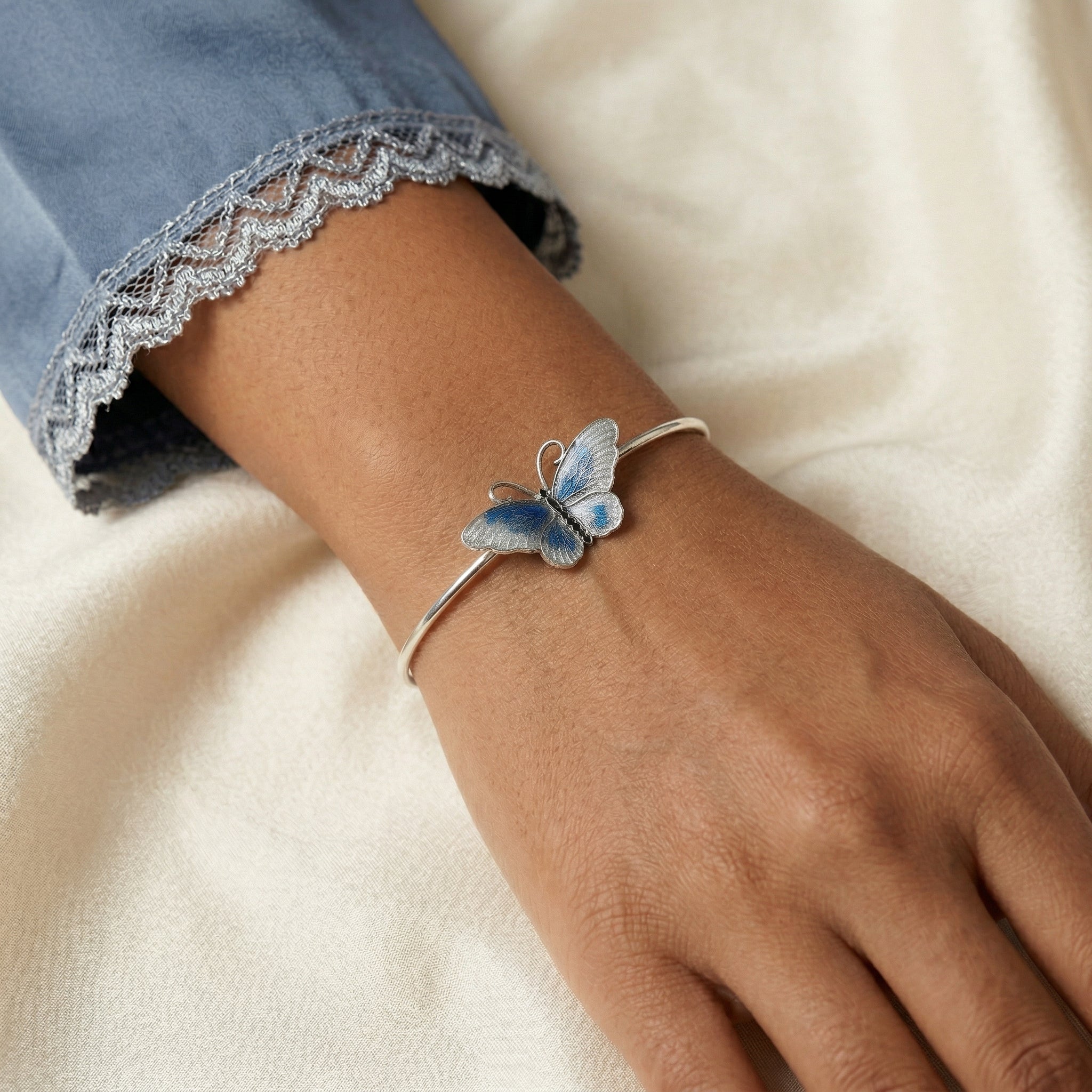 Silver tone Butterfly's Dance Blue Enamel Spring Hinge Bracelet on a woman's wrist