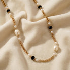 Montana Blue Crystal & Faux Pearl Gold Link Necklace on a beige fabric background