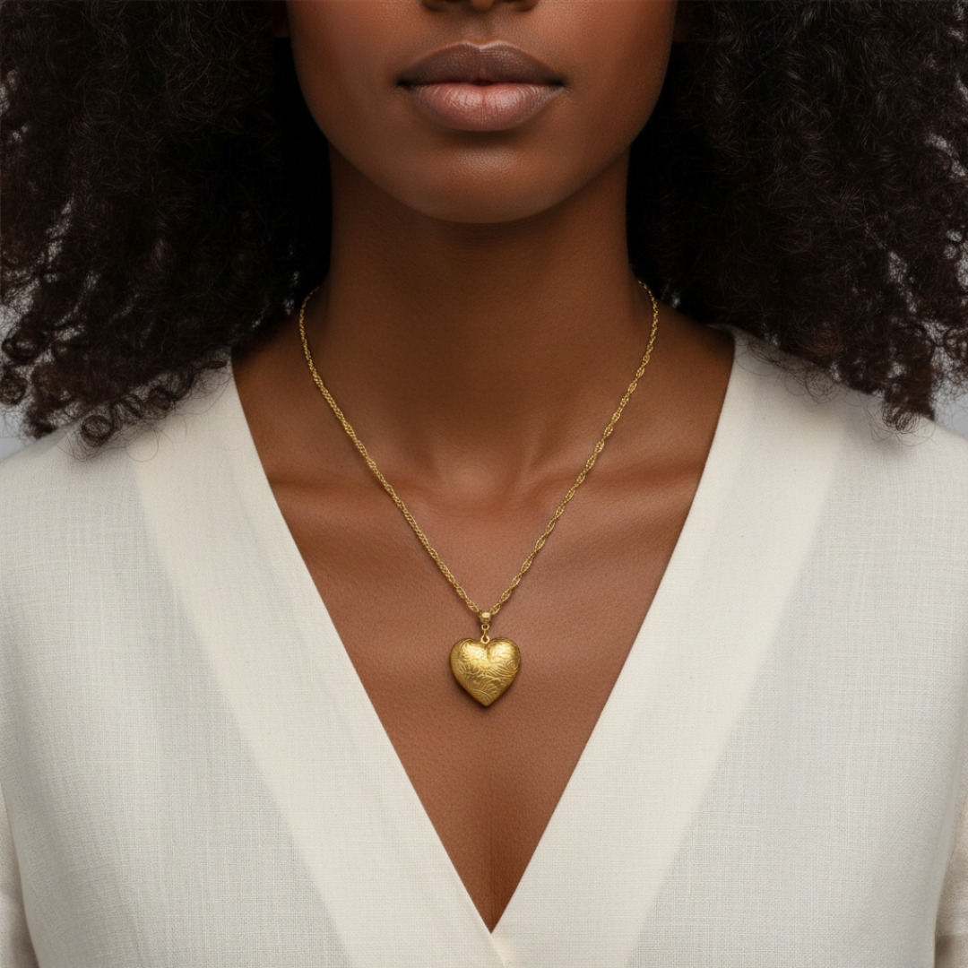 Woman wearing a gold heart-shaped necklace against a neutral background