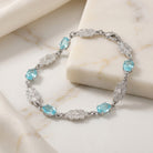 Silver bracelet with blue crystals on a marble surface