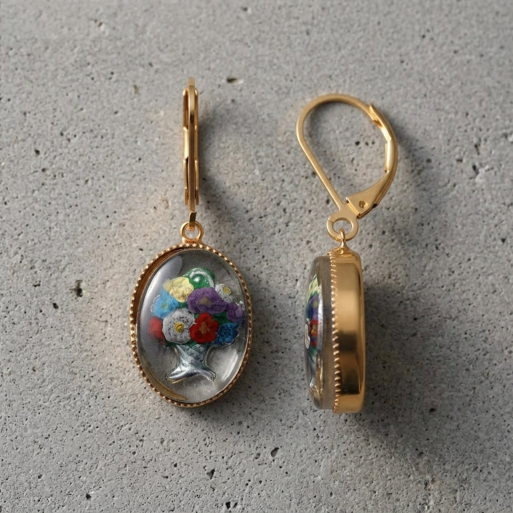 Mixed Flower Bouquet German Enameled Glass Drop Earrings on a gray cement surface