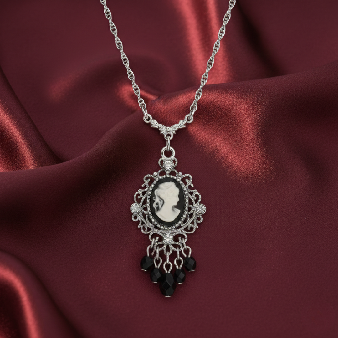 Silver necklace with a cameo pendant on a red satin background