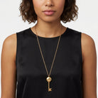 Woman in a black sleeveless top wearing a gold tone Skeleton Key Flower Pendant Photo Locket Necklace 