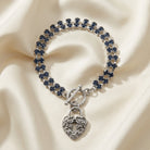 Montana Blue Rhinestone Crystal Skeleton Keyhole Heart Charm Toggle Bracelet resting on cream fabric 