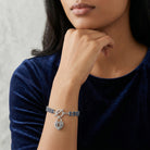 Woman in a dark blue top posing a Montana Blue Rhinestone Crystal Skeleton Keyhole Heart Charm Toggle Bracelet on her wrist