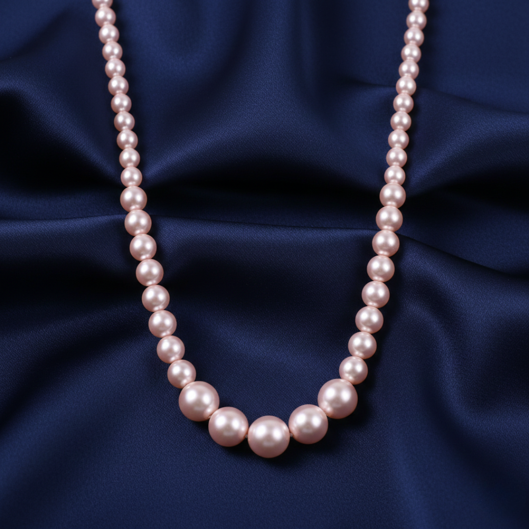 Rosabella Pink faux pearl necklace on a dark blue fabric background