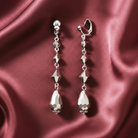 Silver earrings clip-on earrings on a burgundy satin background