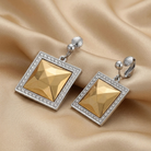 Fusion lux square earrings with silver accents on a beige fabric background