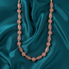 Necklace with pink beads on a teal satin background