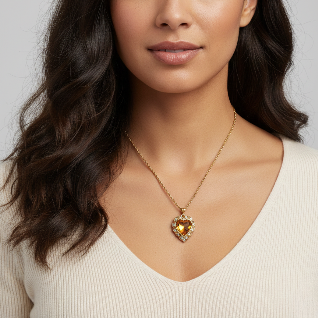 Woman wearing a gold necklace with a heart-shaped pendant on a plain background