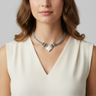 Woman wearing a silver necklace with a neutral background