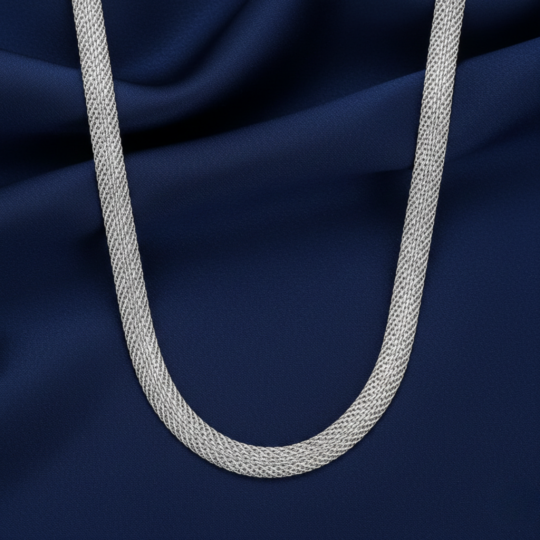 Silver tube chain necklace on a dark blue fabric background