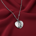 Silver necklace with a cat pendant on a red fabric background