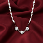 Faux peark necklace with silver crystals on a red fabric background