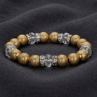 Bracelet with gold tone beads and clear crystals on a dark fabric background