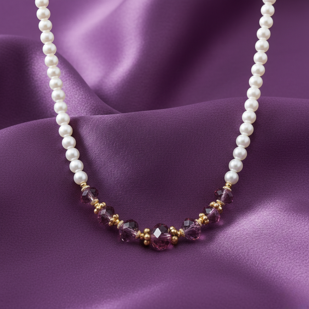 Pearl necklace with purple and gold beads on a purple fabric background