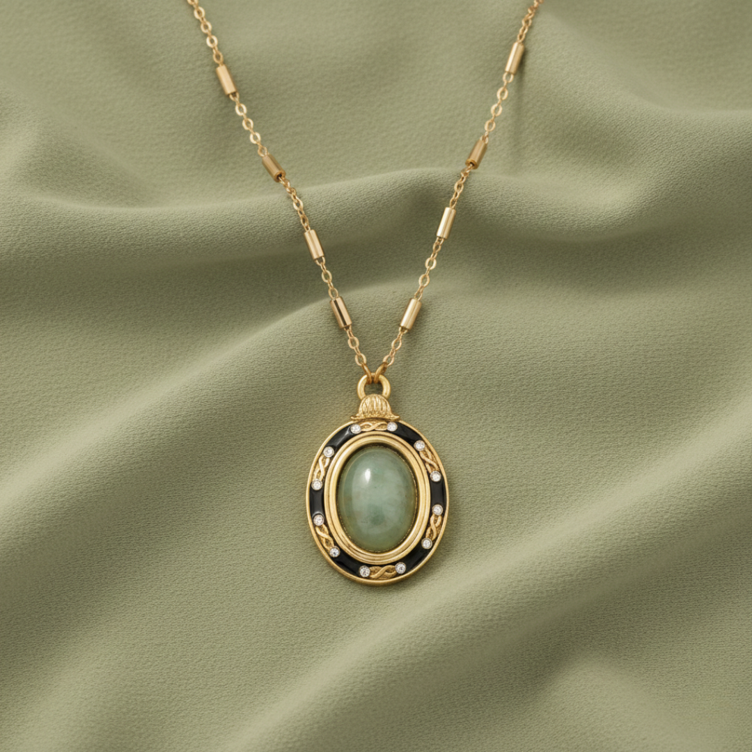 Gold necklace with a pendant on a green fabric background