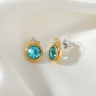Gold earrings with turquoise crystals on a white background