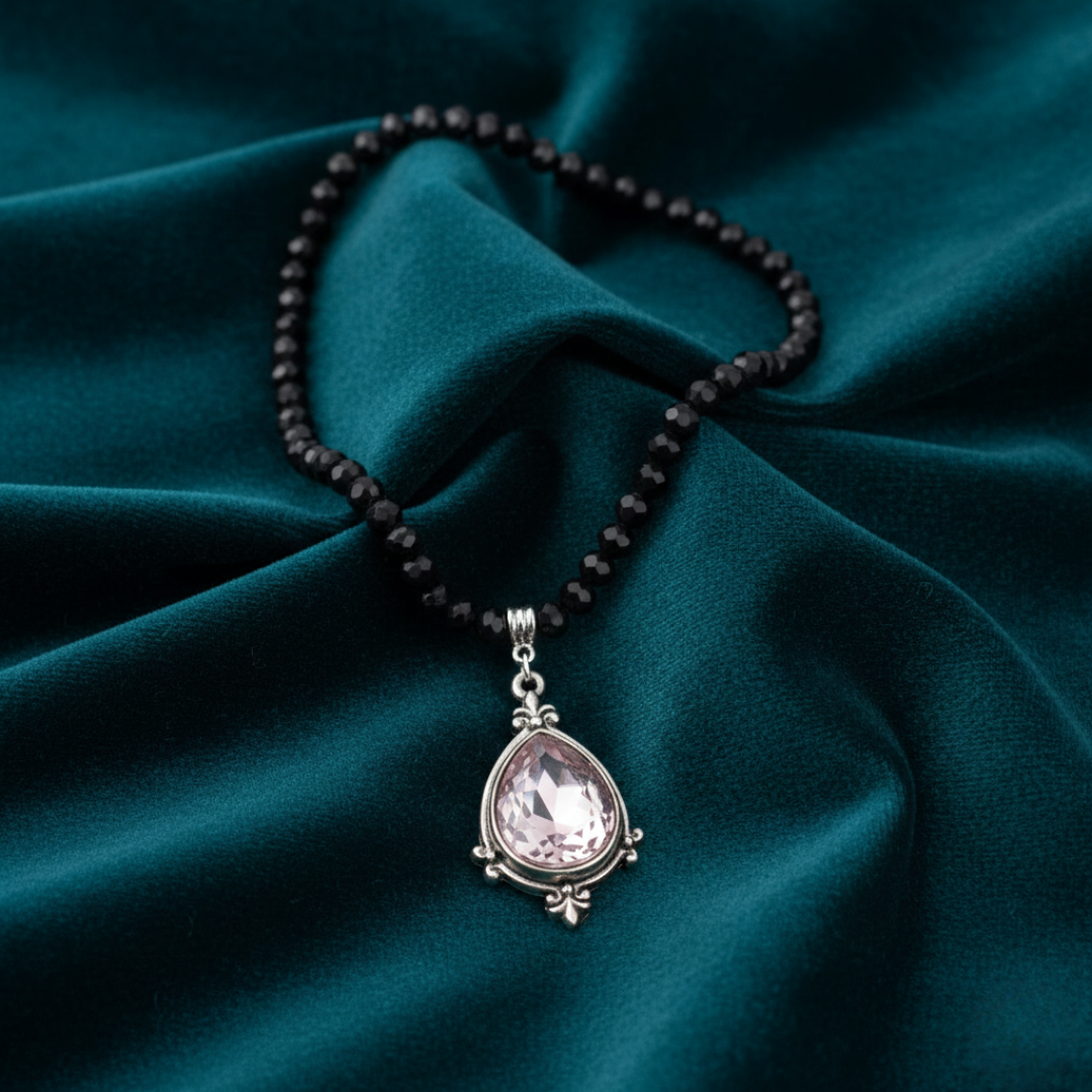 Necklace with a teardrop pendant on dark green fabric