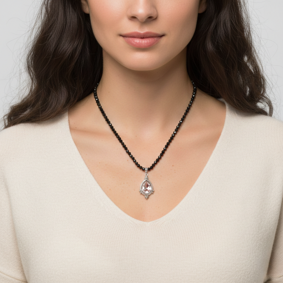Woman wearing a necklace with a pendant against a neutral background
