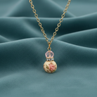 Necklace with floral pendant on a teal fabric background