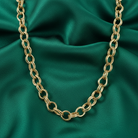 Gold chain necklace on a green satin background