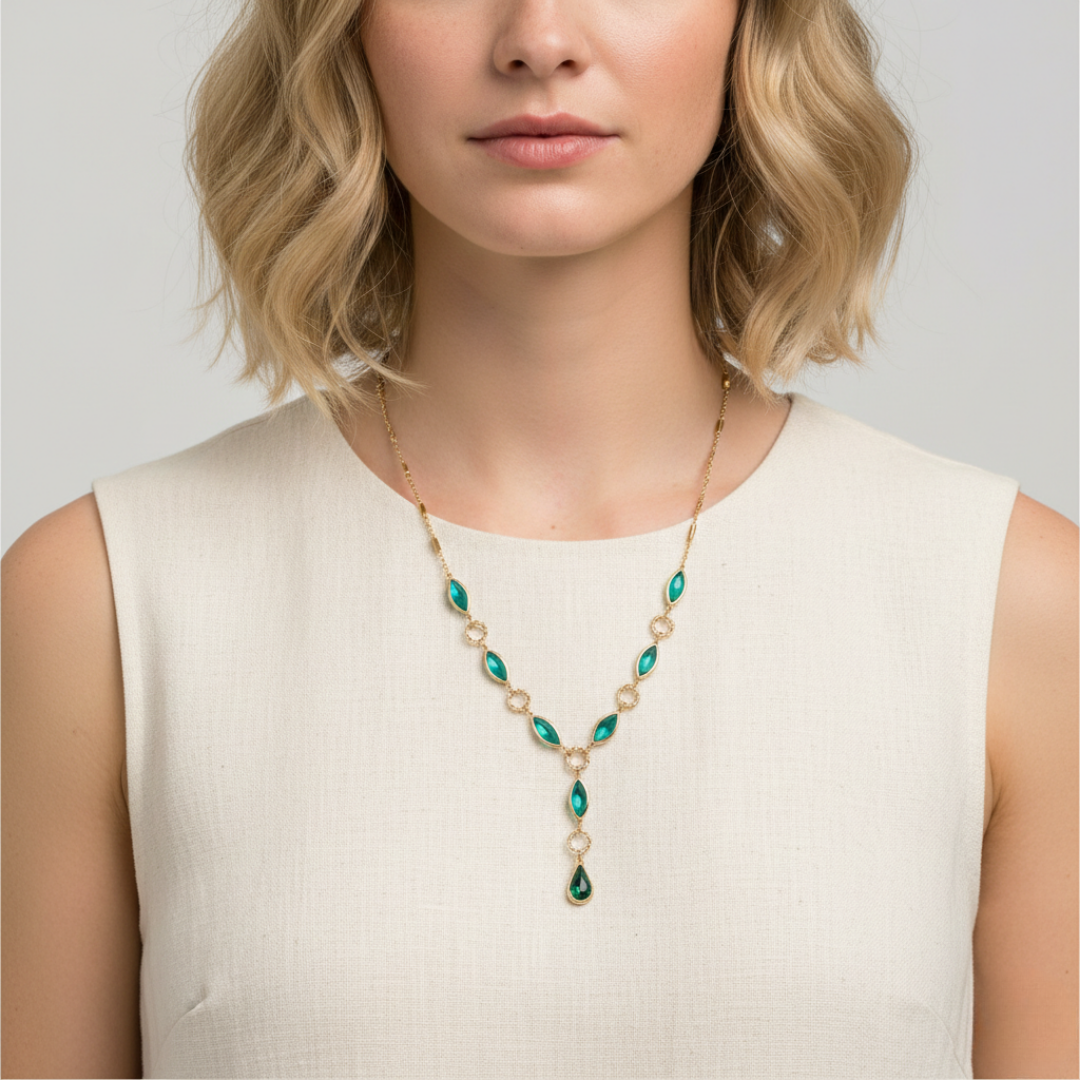 Woman wearing a necklace with green and gold beads on a plain background