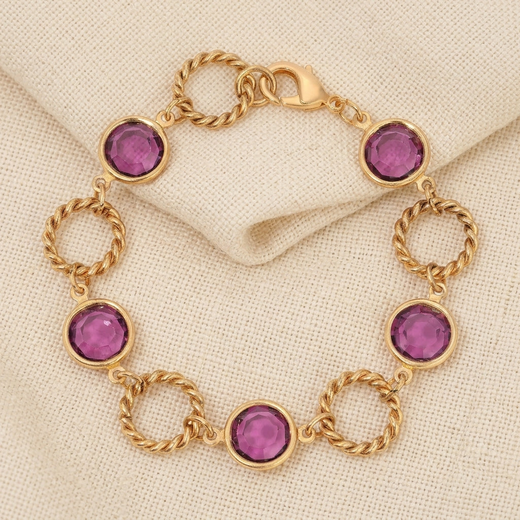 Gold bracelet with purple Austrian crystals on a beige fabric background