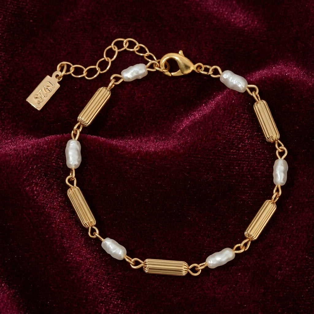 Gold bracelet with pearls on a burgundy velvet background