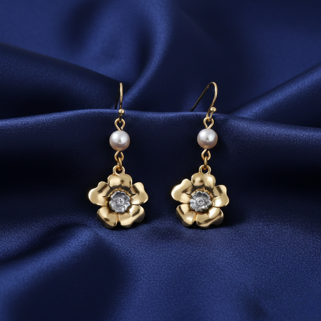 Gold floral earrings with faux pearls on a blue satin background