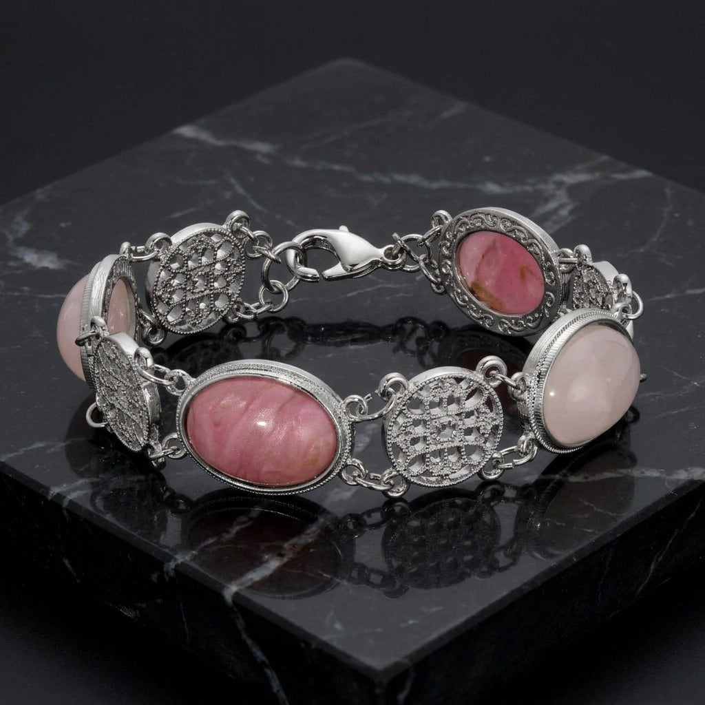 Silver bracelet with pink stones on a dark marble surface
