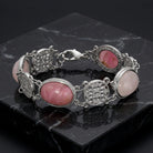 Silver bracelet with pink stones on a dark marble surface