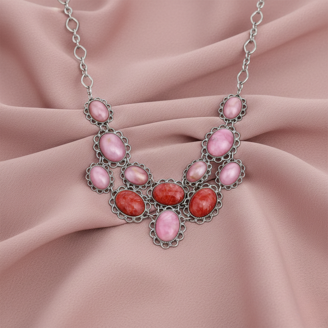 Necklace with pink and red stones on a pink fabric background