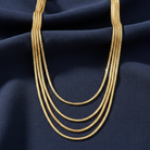 Gold necklace on a dark blue fabric background