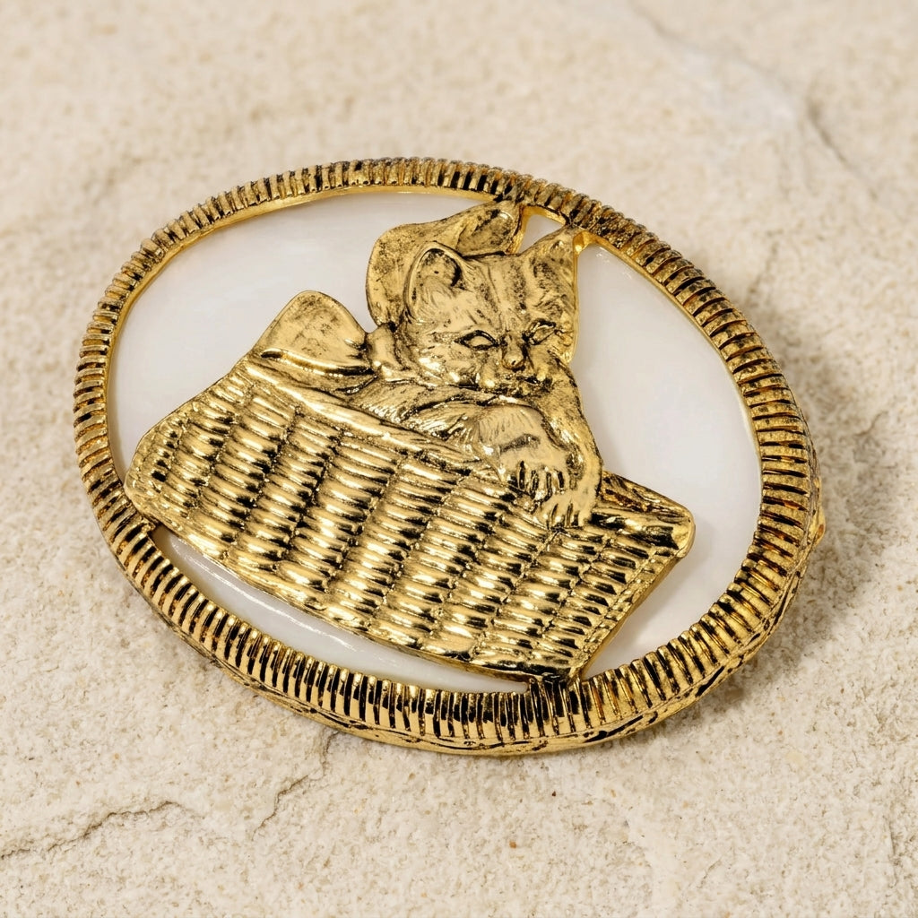 Gold brooch with a cat design on a beige background