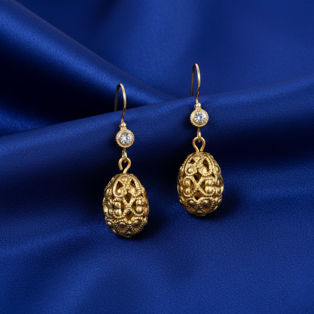 Gold Oval Filigree Bead Crystal Drop Earrings on a blue fabric