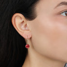 A close-up of a model's ear wearing a Classic Round Dark Pink Crystal Drop Earrings