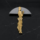 Gold brooch of a 1920s woman on a black marble background