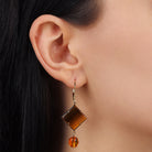 Woman's ear wearing a Square Tiger's Eye Gemstone & Crystal Drop Dangling Earrings