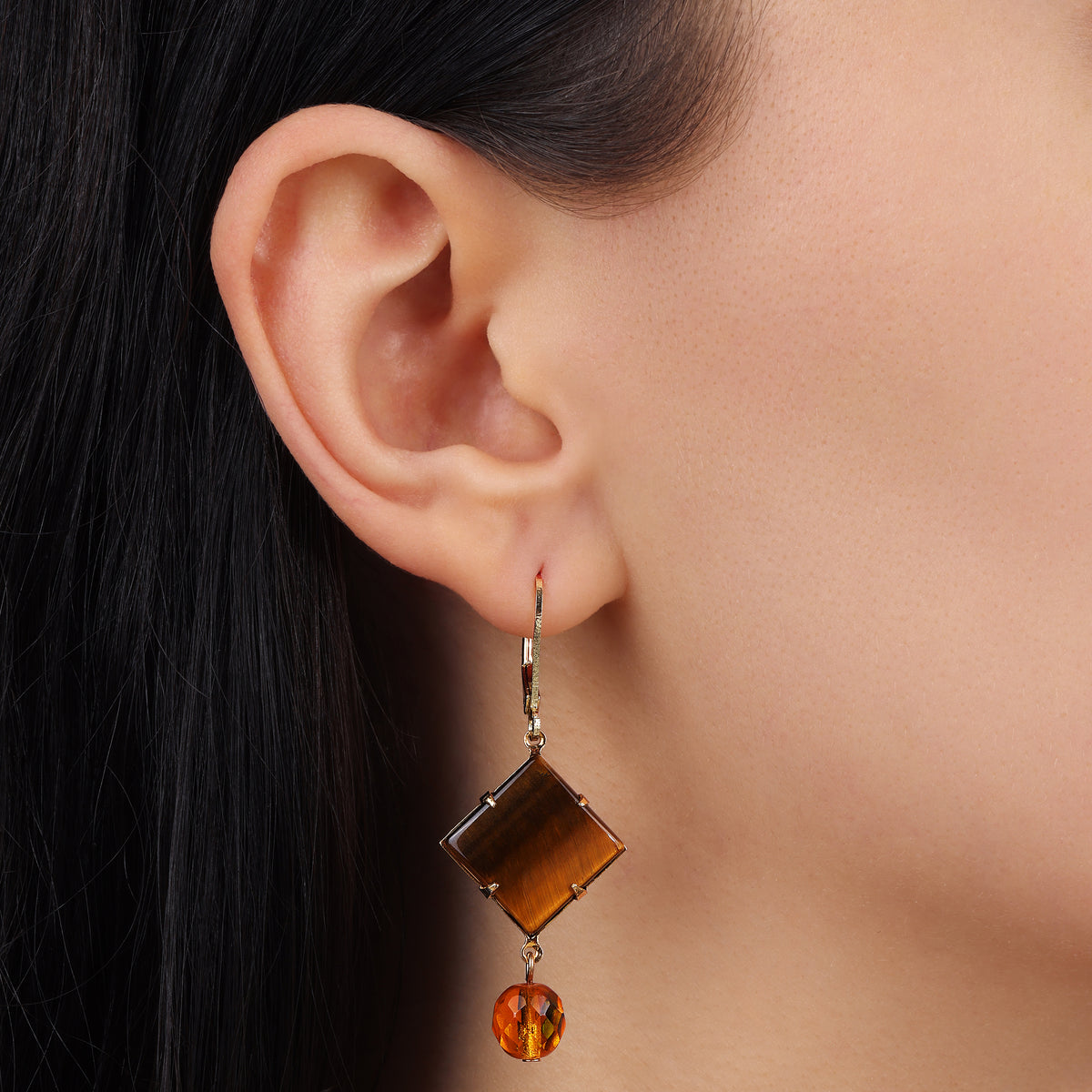 Woman's ear wearing a Square Tiger's Eye Gemstone & Crystal Drop Dangling Earrings